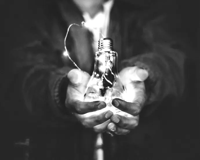 man holding incandescent bulb