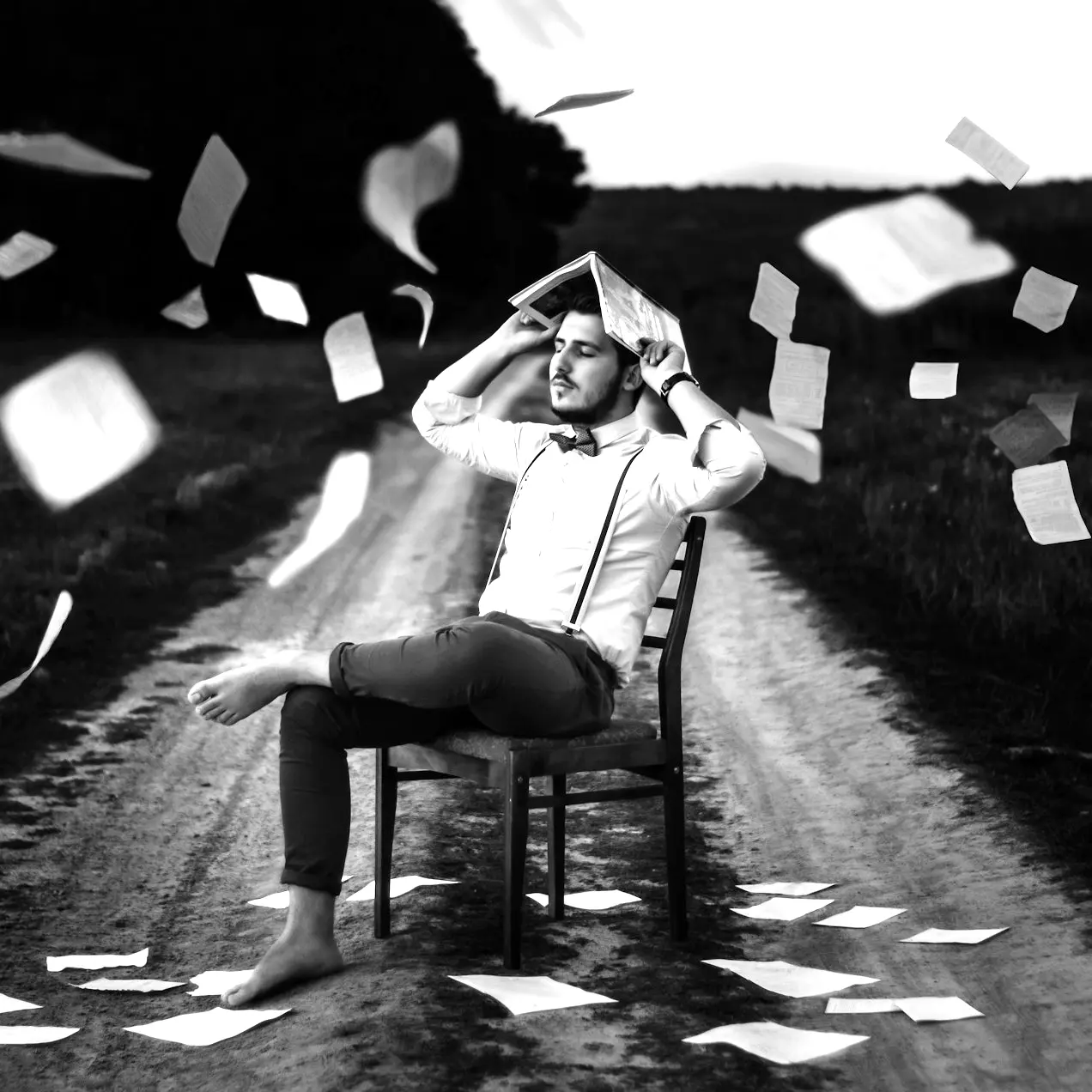 man sitting on chair with book