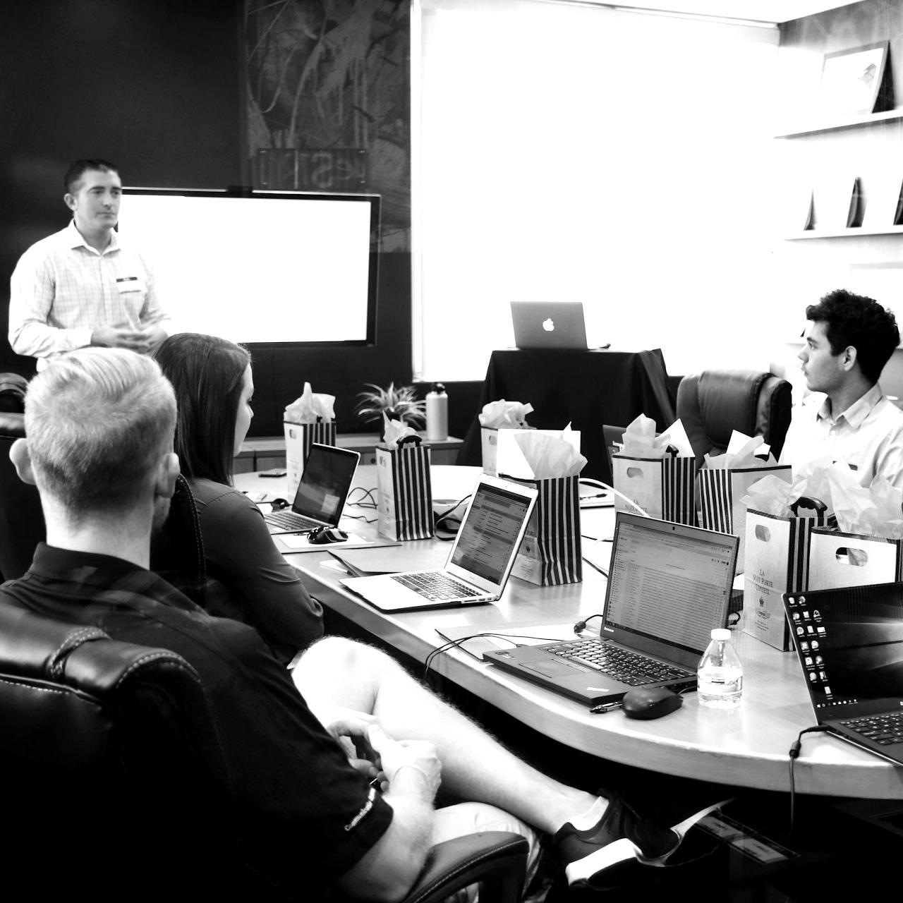 man standing in front of people sitting beside table with laptop computers